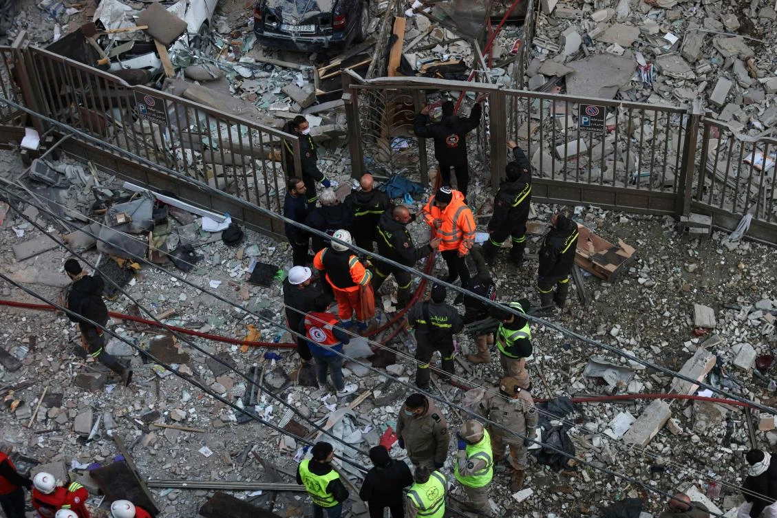Emergency personnel and residents gather at the site of an Israeli airstrike that targeted a building in the Aisha Bakkar neighborhood of Beirut on Mar. 11, 2026. (AFP)