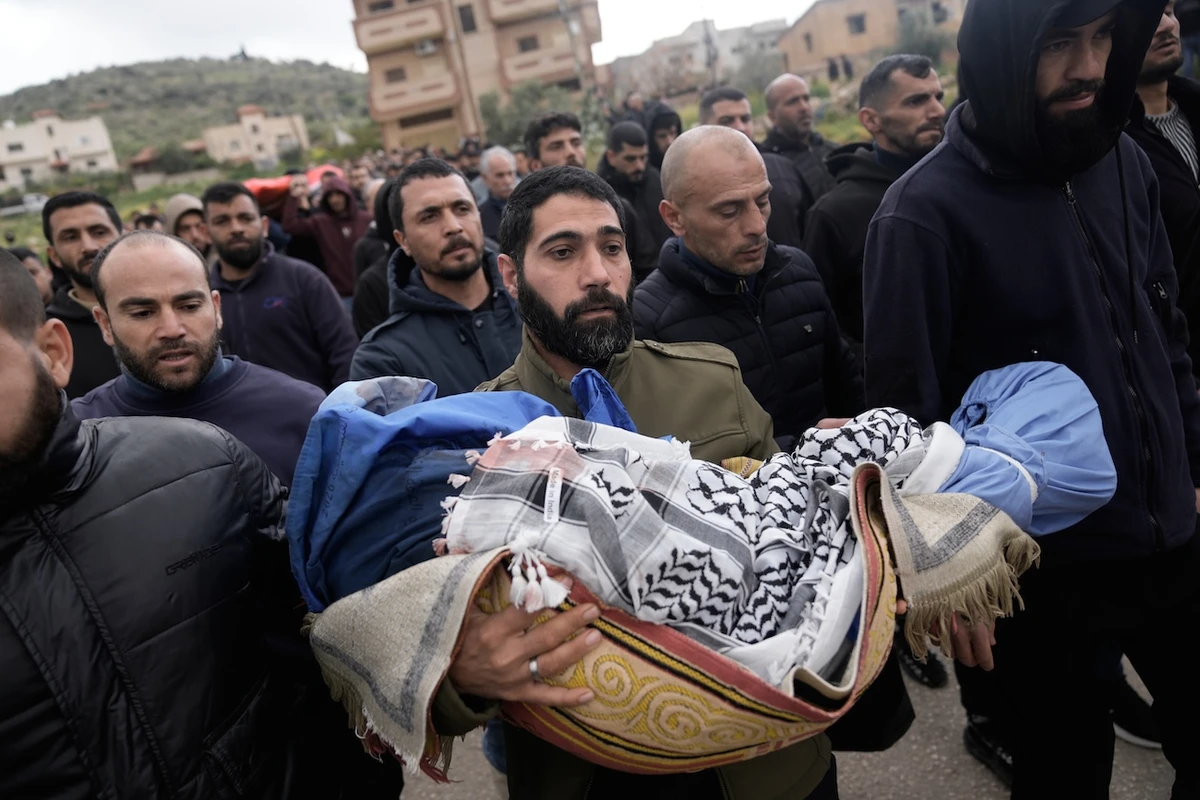Palestinian man carries Muhammad Bani Odeh, 5, at the funeral of four members of the Odeh family who were killed in their car by Israeli security forces during an army operation in Tammun, West Bank, Sunday, March 15, 2026. (AP)