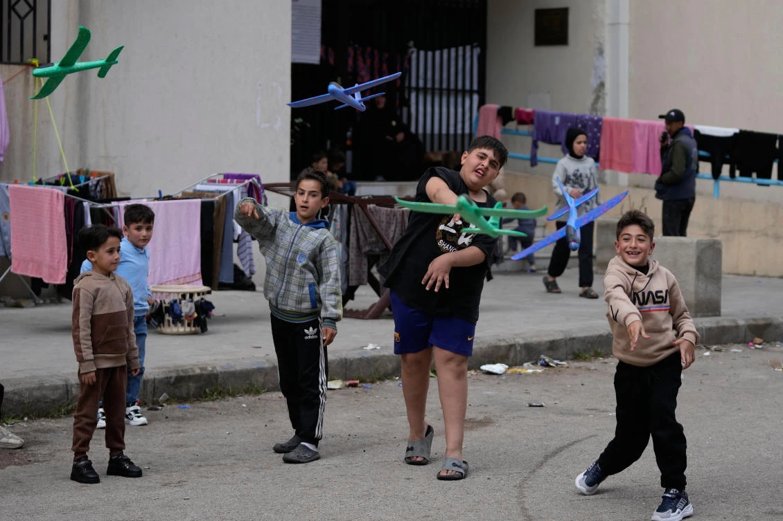 Displaced boys who fled Israeli strikes from south Lebanon, plays with toy planes at a school playground which turn into a shelter, in the southern port city of Sidon, Mar. 16, 2026. (AP)