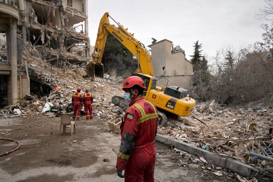 Iranian Red Crescent emergency workers use a bulldozer to clear rubble from a residential building that was hit in an earlier U.S.-Israeli strike in Tehran, Iran. (AP)