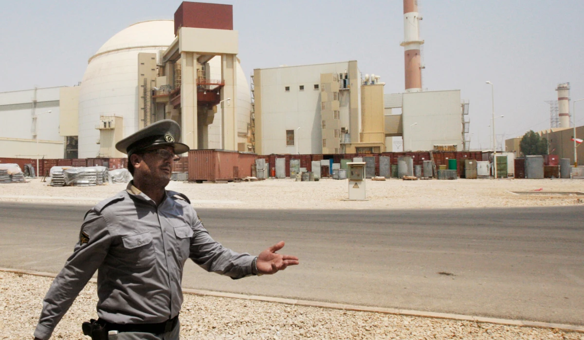 In this Aug. 21, 2010 file photo, an Iranian security officer directs media at the Bushehr nuclear power plant, with the reactor building seen in the background, just outside the southern city of Bushehr, Iran. (AP)