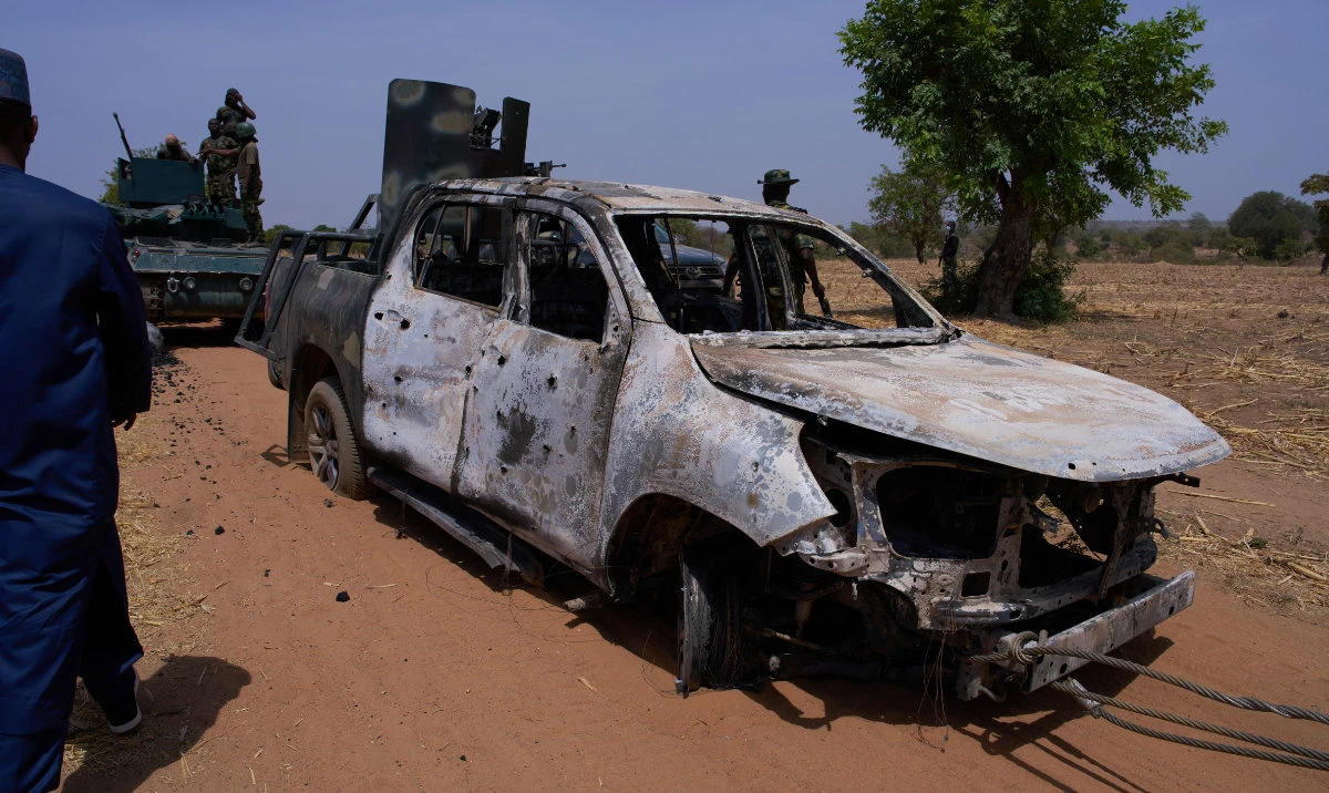 In this photo released by the Kebbi State Government, a man inspects a burned military vehicle following a late Tuesday ambush by armed militants in Shanga, Kebbi, northern Nigeria, Wednesday, March. 25, 2026. (AP)