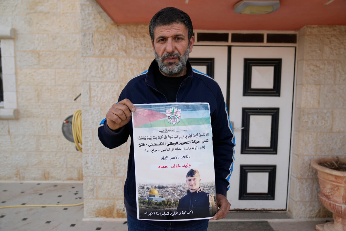 Khalid Ahmad holds a poster of his 17-year-old son, Walid Ahmad, who died in an Israeli prison, that reads in Arabic, "The hero prisoner Martyr, mercy and eternity for our righteous Martyrs," in the West Bank town of Silwad, northeast of Ramallah, March 26, 2025. (AP)