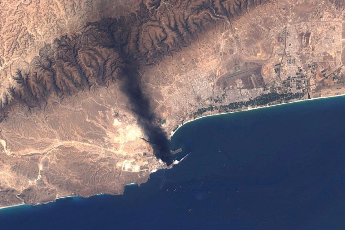 Above, a satellite image made available by the US Geological Survey shows smoke billowing from the Mina Petroleum facility at Salalah Port in Oman on March 16, 2026. (US Geological Survey/AFP)