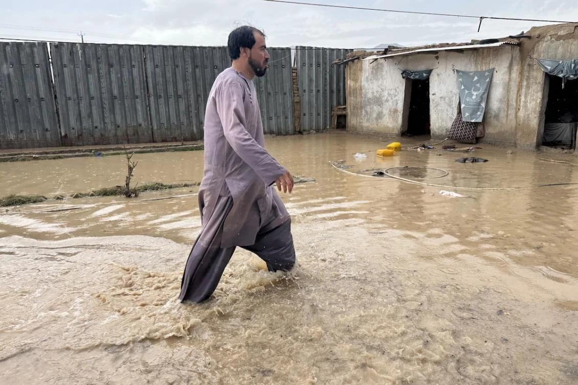 An Afghan man wades across floodwaters in a yard, after rainfall in Kandahar on March 25, 2026. (FILE/AFP)
