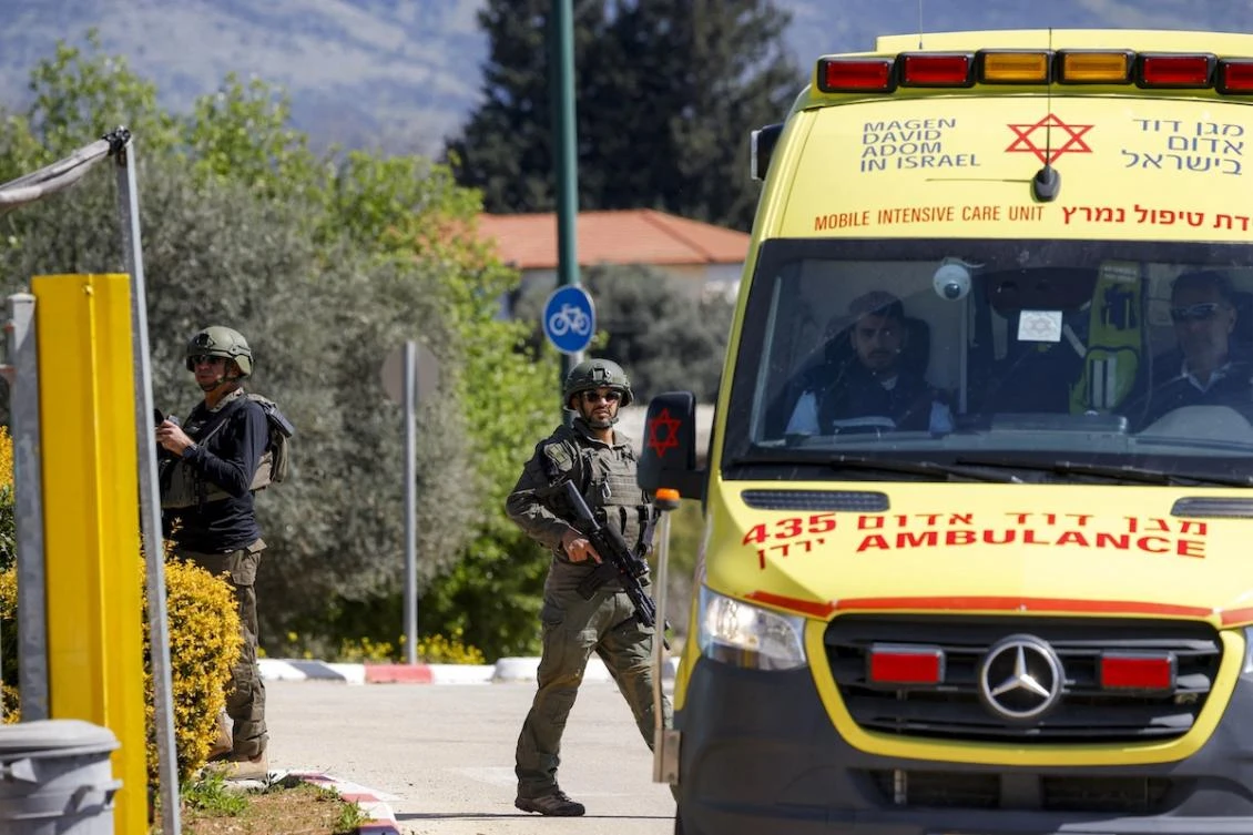 Israeli army soldiers walk near an ambulance positioned at the entrance of Moshav Kfar Yuval in northern Israel near the border with southern Lebanon on March 3, 2026. (FILE/AFP)