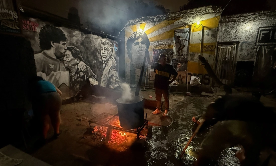 A man cooks stew for residents of the working-class neighbourhood of Villa Fiorito at a soup kitchen set up in the house where late soccer legend Diego Armando Maradona spent his early childhood, on the outskirts of Buenos Aires, Argentina. (Reuters)