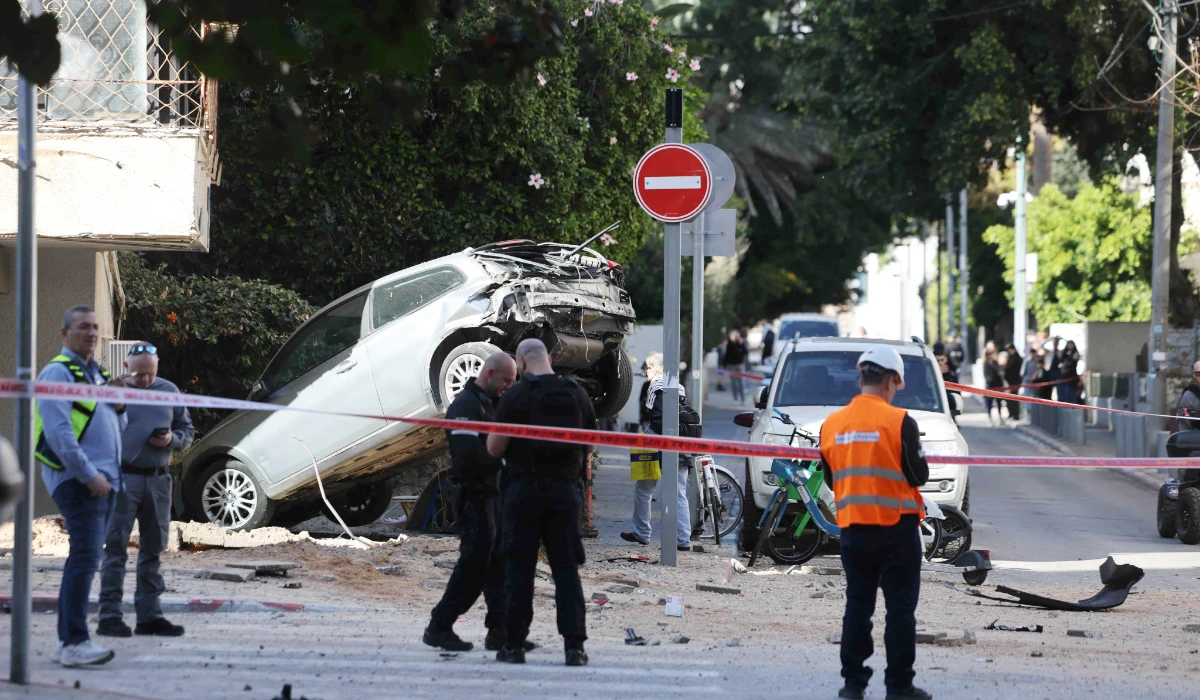Israeli police and first responders gather at the site of an Iranian missile strike in Tel Aviv, on March 8, 2026. (AFP)