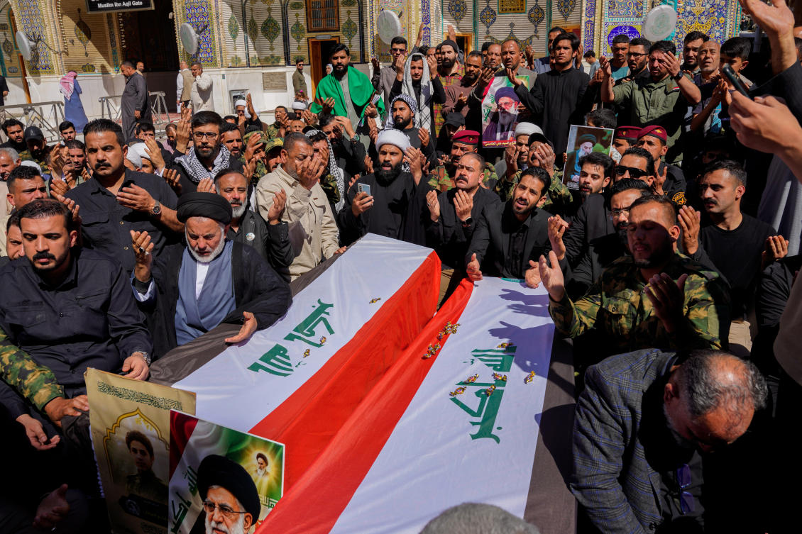 Relatives pray near the coffin of Popular Mobilization Forces fighter, in Najaf, Iraq on Wednesday. (AP)