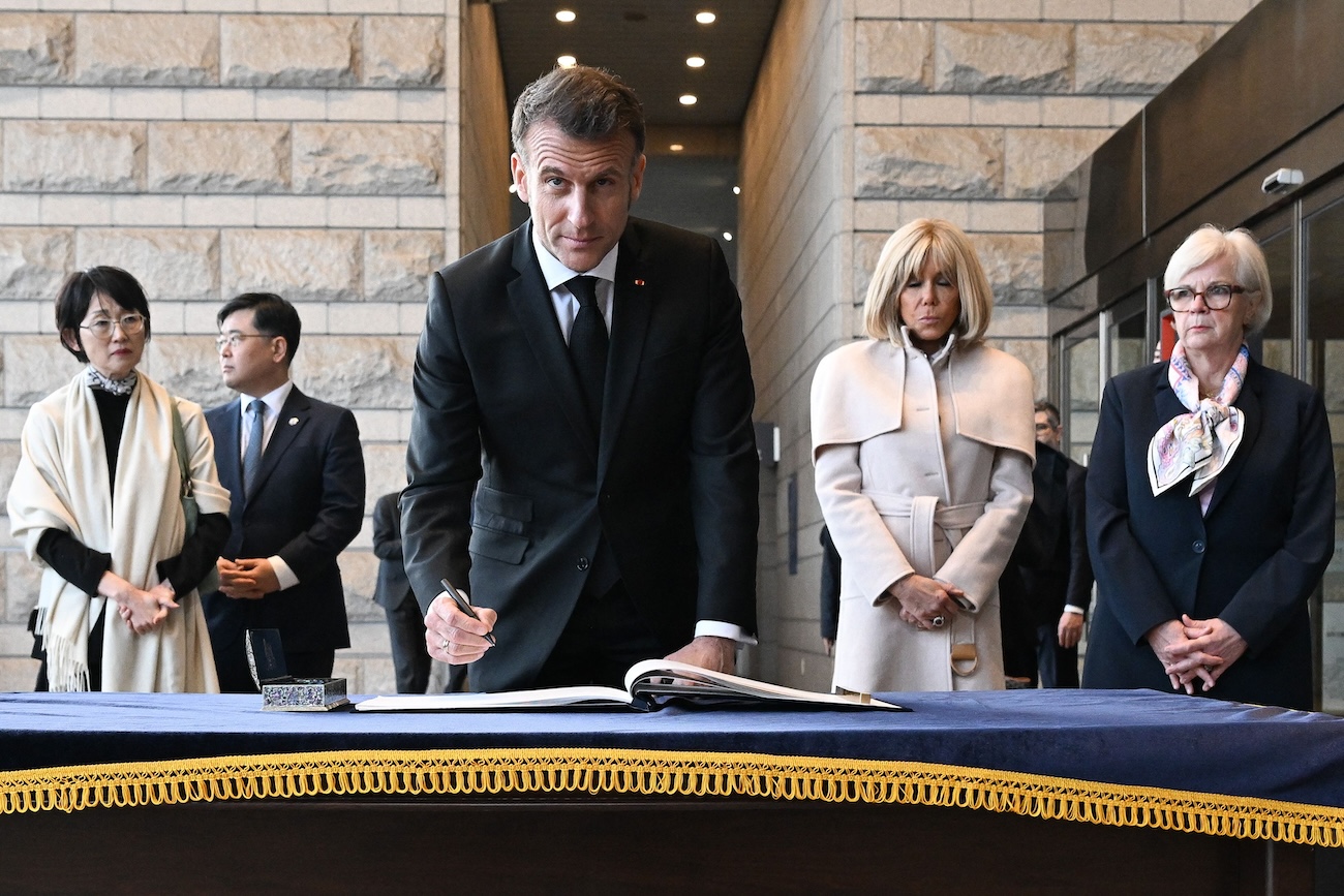 French President Macron signs the guestbook during a visit at the War Memorial of Korea with his wife Brigitte Macron and French Defence Minister Catherine Vautrin (R) in Seoul on April 2, 2026. (AFP)