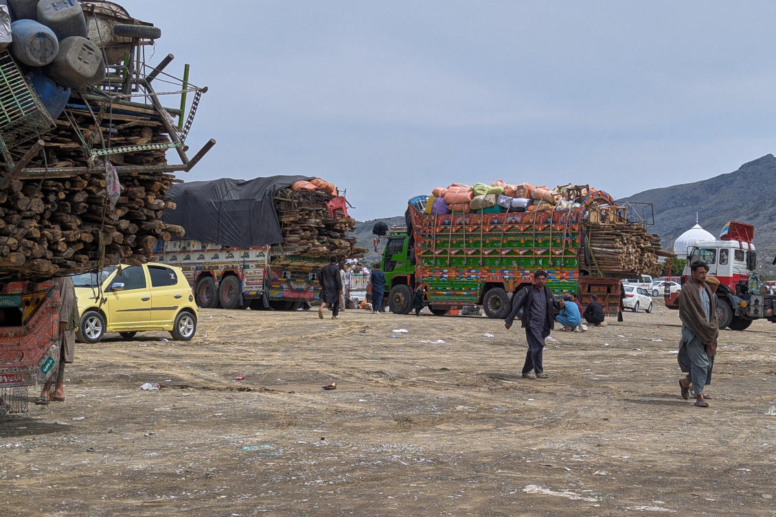 Afghan refugees walk next to trucks loaded with their family's belonging as they wait for registration to leave for their homeland, at outside a repatriation centre in Landi Kotal, a town of Pakistan's Khyber district bordering with Afghanistan, Wednesday, April 1, 2026. (AP Photo/Akmal Khan)