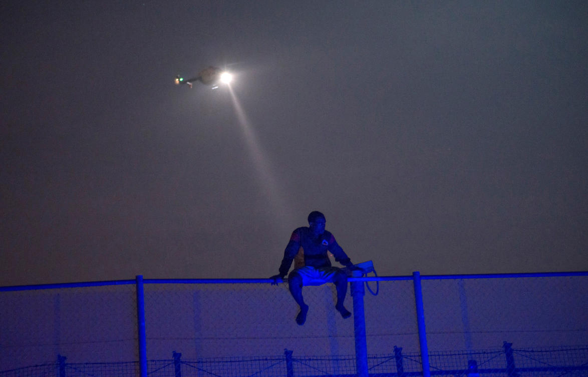 An African migrant sits on top of a border fence covered in razor wire between Morocco and Spain's north African enclave of Melilla, during a latest attempt to cross into Spanish territory, June 14, 2014. (REUTERS)