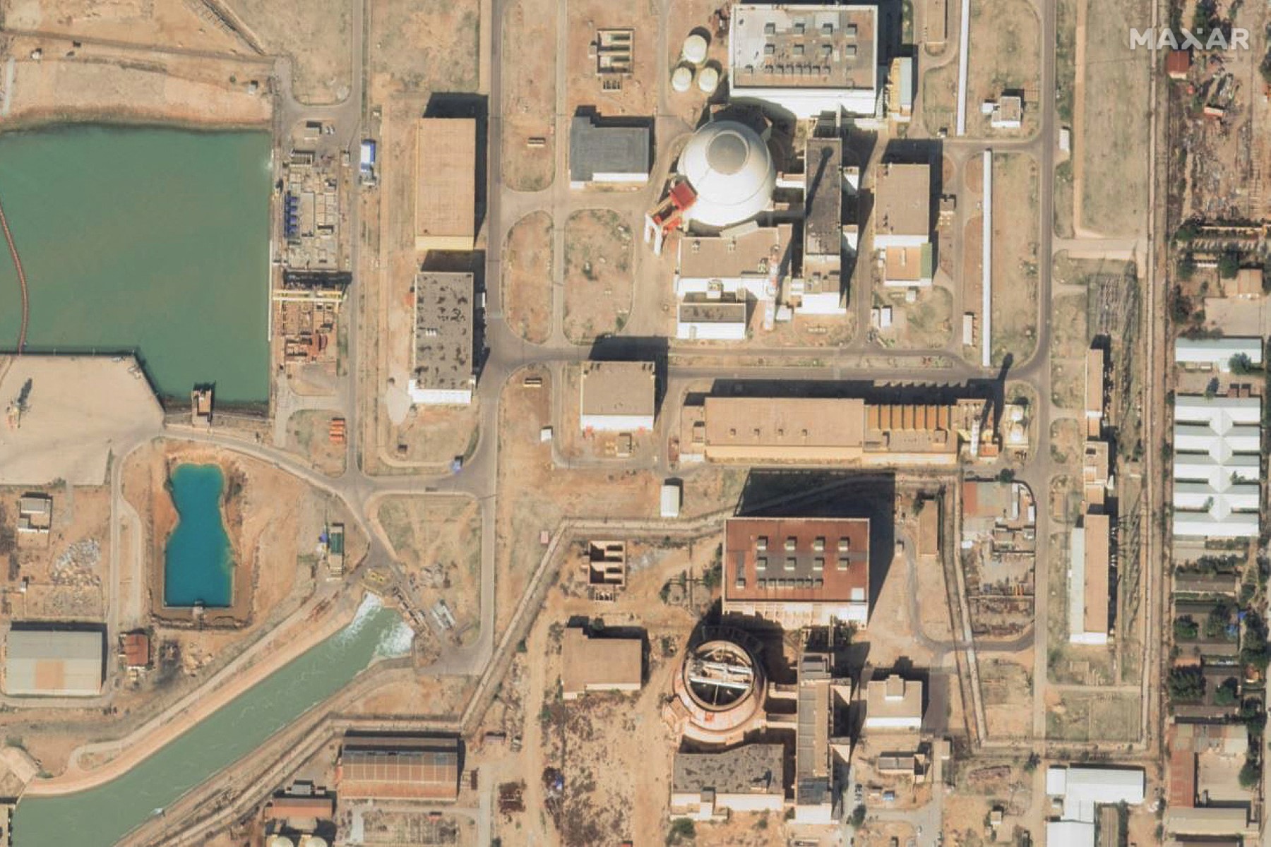 Above, satellite image of the Bushehr reactors on Jan. 1, 2025. A projectile from a US-Israeli attack hit near the Bushehr nuclear power plant on April 4, 2026. (Maxar Technologies/AFP)