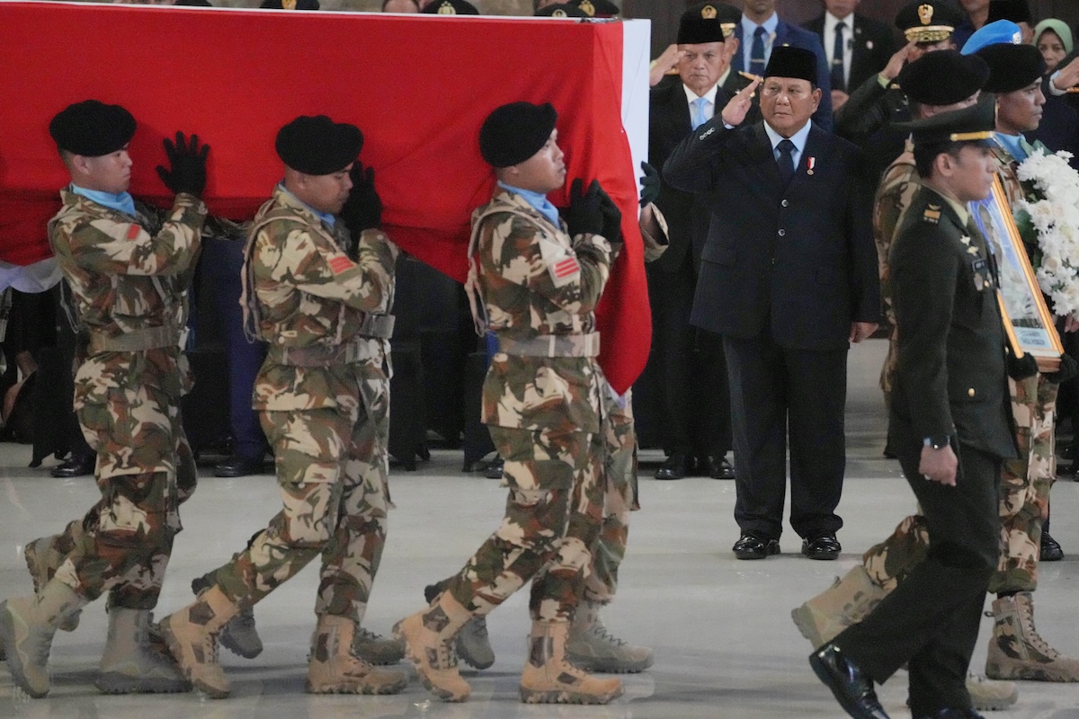 Indonesian President Prabowo Subianto, right, salutes as soldiers carry one of the coffins of Indonesian peacekeepers who were killed while serving with the UN Interim Force in Lebanon during a memorial service in Jakarta on Saturday, April 4, 2026. (AP)