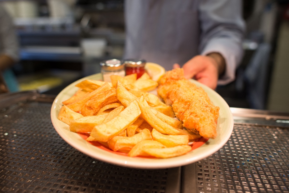 A chef poses with a plate of fish and chips at Poppies fish and chip restaurant in east London, UK. (AFP)
