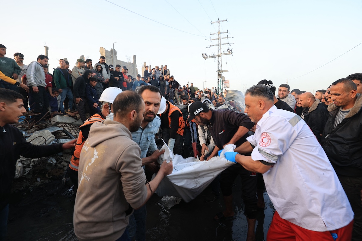 First responders carry parts of a body recovered from a vehicle that was targeted by an earlier Israeli strike in Maghazi camp in the central Gaza Strip on April 4, 2026. (AFP)