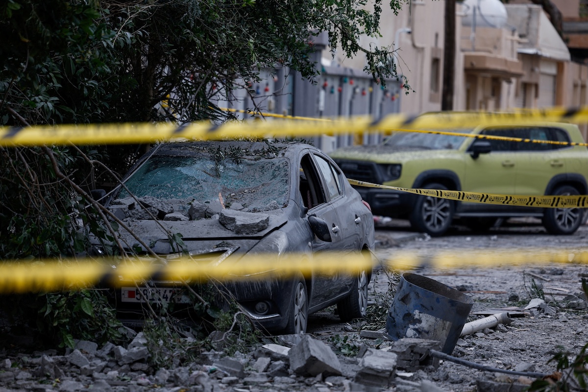 Above, a wrecked car near damaged buildings at the site of an impact of a falling debris of an intercepted Iranian drone in Sitra, Bahrain on April 4, 2026. (Reuters)
