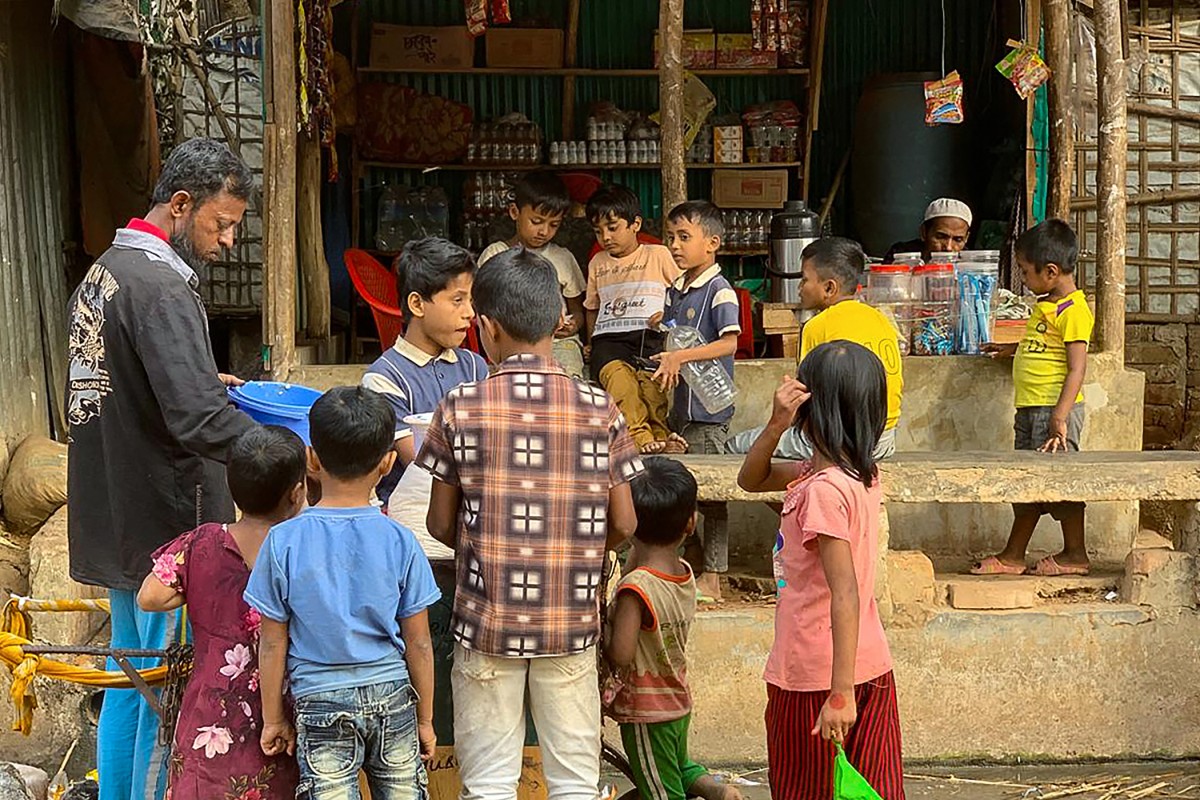 Rohingya refugee children surround a street vendor at the Kutupalong refugee camp in Ukhia, Bangladesh. (AFP)