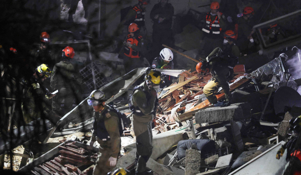 Israeli search and rescue personnel work on the site of a residential building that was destroyed by an Iranian strike in the neighbourhood in Haifa on April 5, 2026. (AFP)