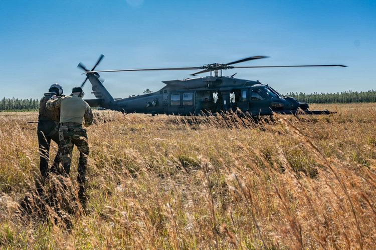 In this photo from the US Defense Visual Information Distribution Service (DVIDS) website, a downed airman is shown being taken to safety by a rescuer during a combat recovery exercise. (DVIDS photo)