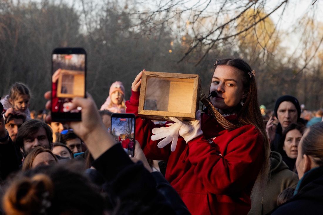 A volunteer carries a box containing a bat as members of the public take pictures during the release of the bats rescued during the winter, organised by the Ukrainian Center for Chiropteran Rehabilitation, in Kyiv, Ukraine. (AP)