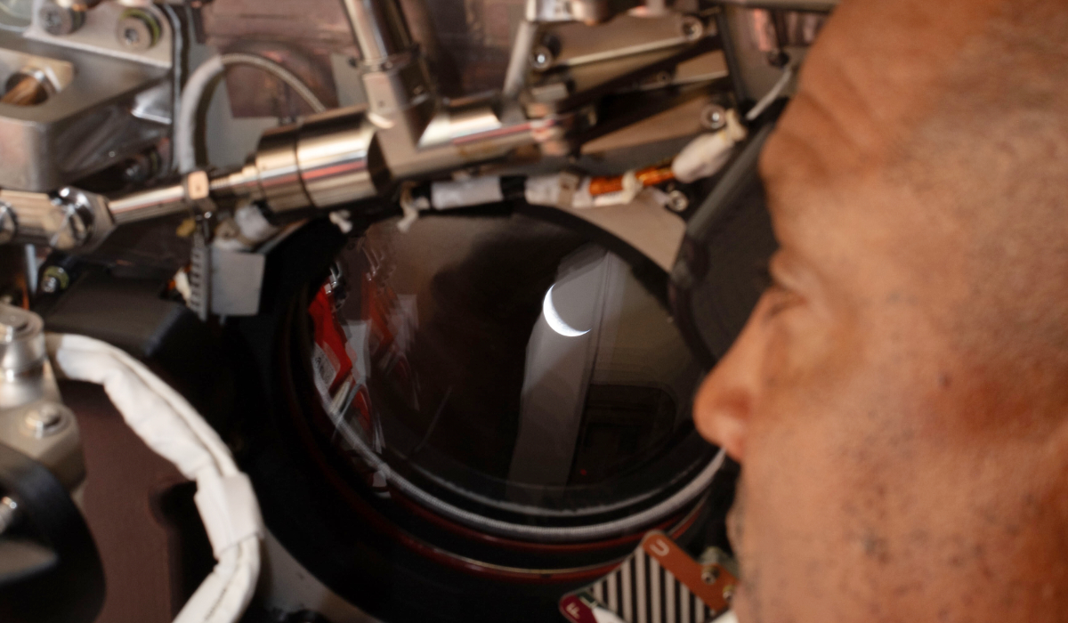 In this photo provided by NASA, Artemis II pilot and NASA astronaut Victor Glover peers out one of the Orion spacecraft's windows looking back at Earth ahead of the crew's lunar flyby, Monday, April 6, 2026. (NASA via AP)