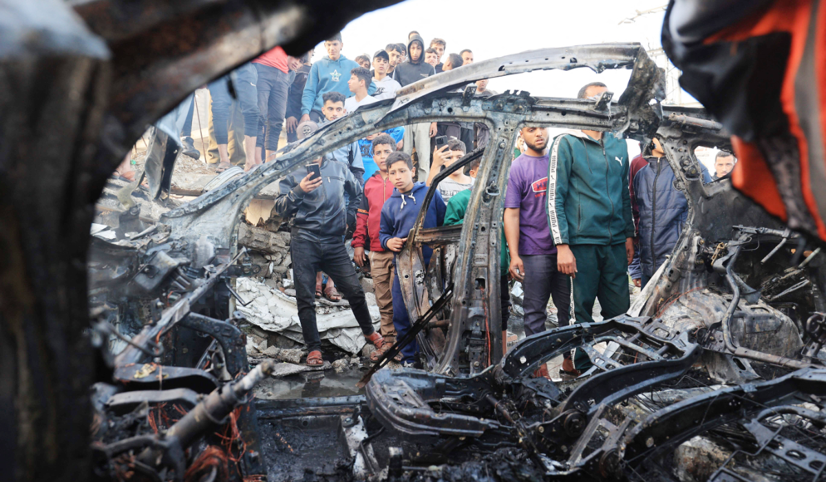 Palestinians inspect a vehicle targeted by an Israeli strike in Maghazi camp for Palestinian refugees in the central Gaza Strip on April 4, 2026. (AFP)