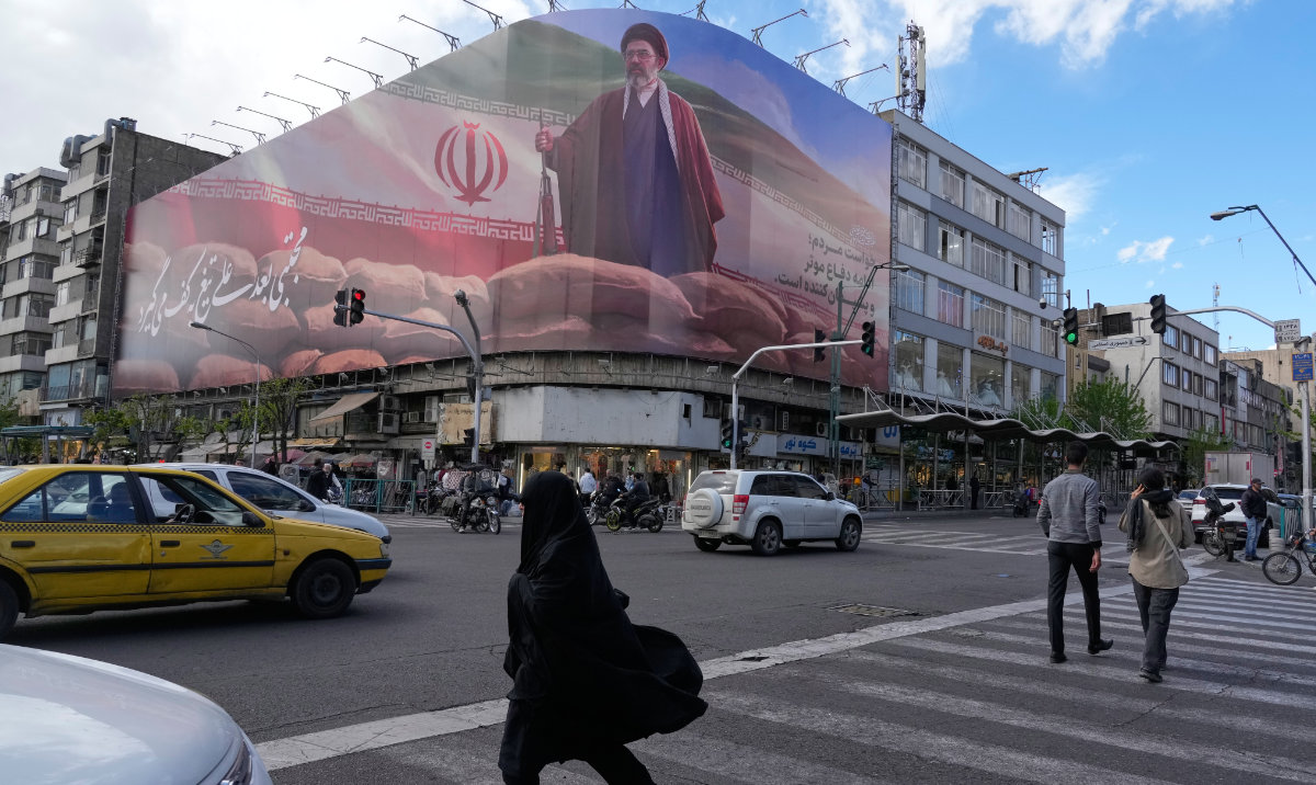 People walk past a billboard that shows a graphic depicting Iran's Supreme Leader Ayatollah Mojtaba Khamenei in downtown Tehran, Iran, Monday, April 6, 2026. (AP)