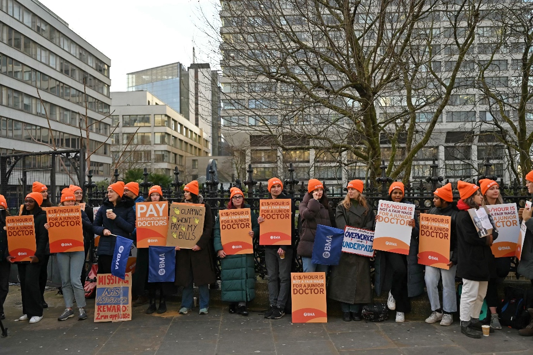 People hold British Medical Association (BMA) branded placards calling for better pay, as they stand on a picket line outside St Thomas' Hospital in central London on January 3, 2024. (AFP)