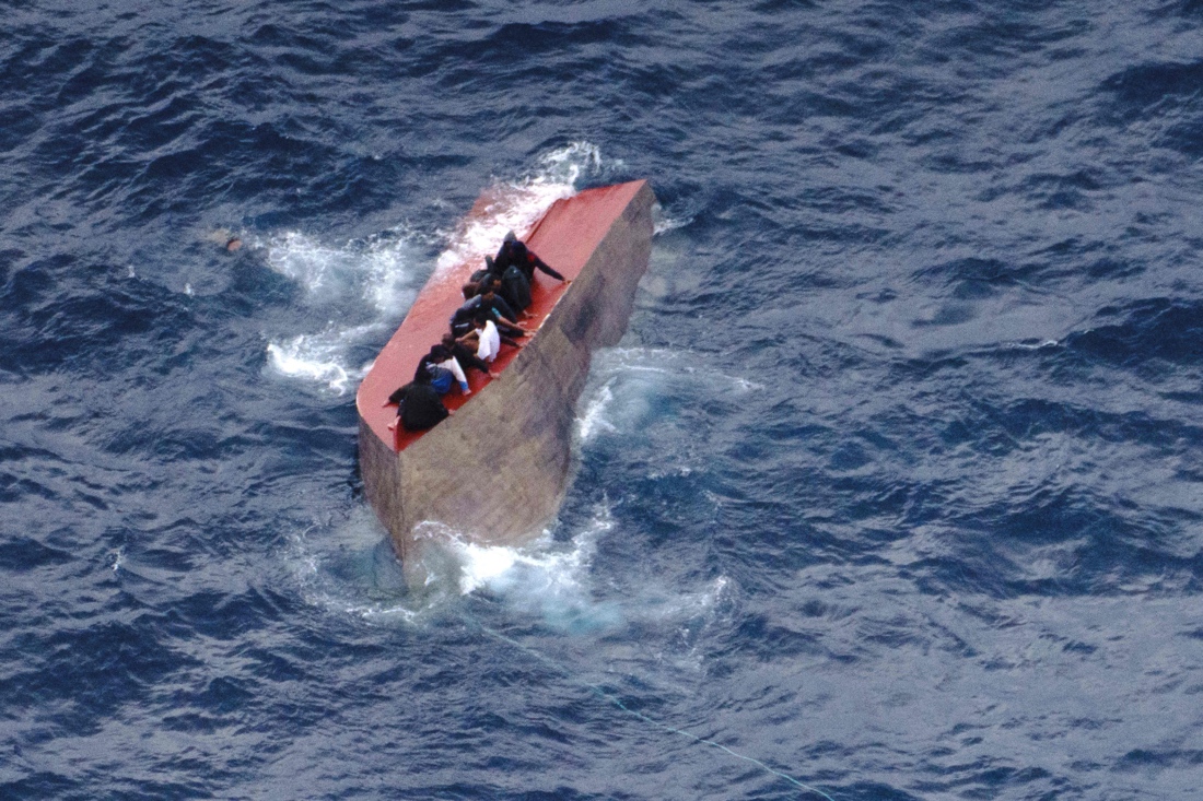 This photo by German NGO Sea-Watch, shows migrants seatted on a capsized boat off Libya. (AFP)