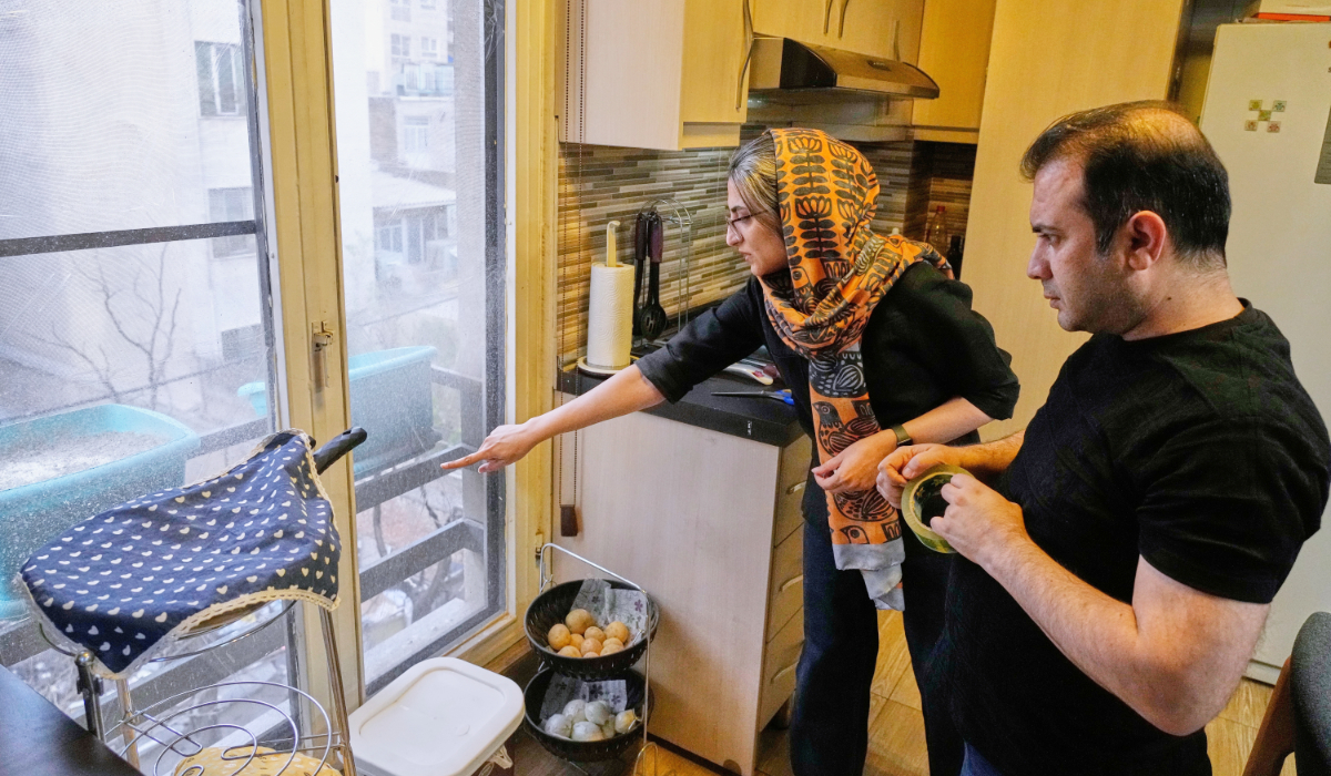 Zahra Arghavan, left, and Mehdi Alishir check one of the windows at their home in Tehran, Iran, Sunday, April 5, 2026. (AP)