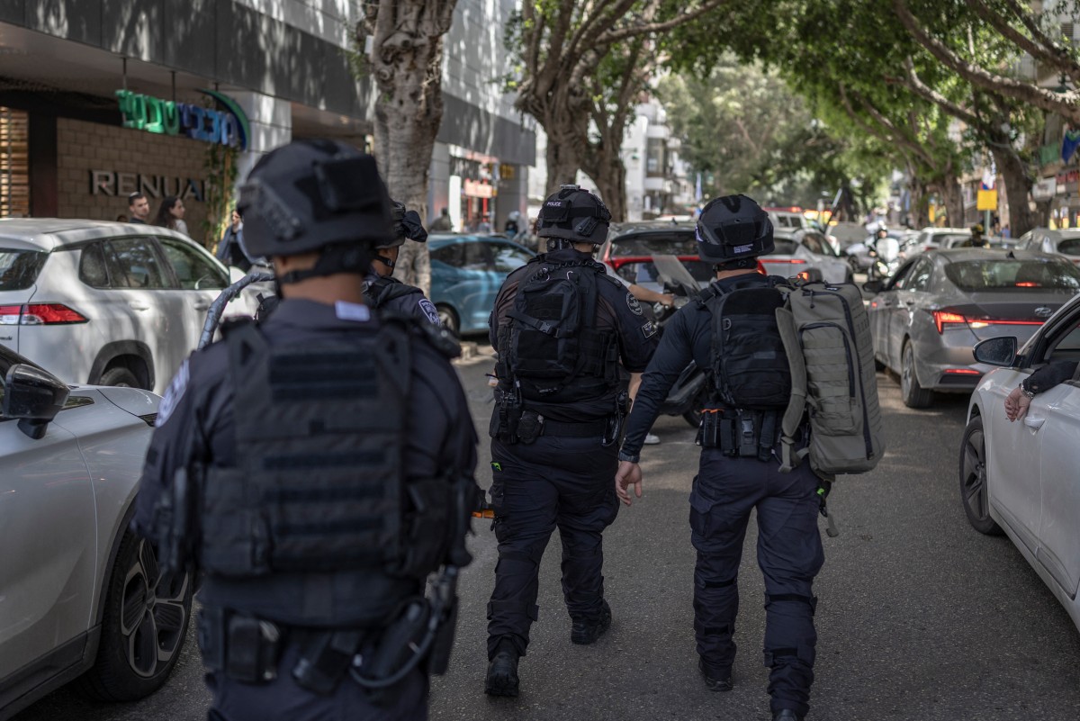 First responders look from the street at a building that was hit by an Iranian projectile attack in Ramat Gan in central Israel, April 6, 2026. (AFP)