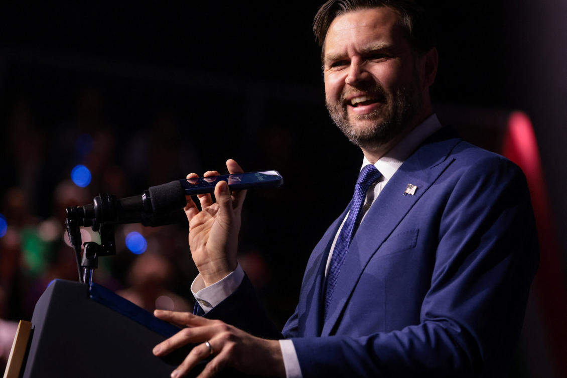U.S. Vice President JD Vance holds a mobile phone while on a call with U.S. President Donald Trump to a microphone during a Day of Friendship event with Hungarian Prime Minister Viktor Orban at MTK Sportpark in Budapest, Hungary, April 7, 2026. REUTERS/Jonathan Ernst/Pool