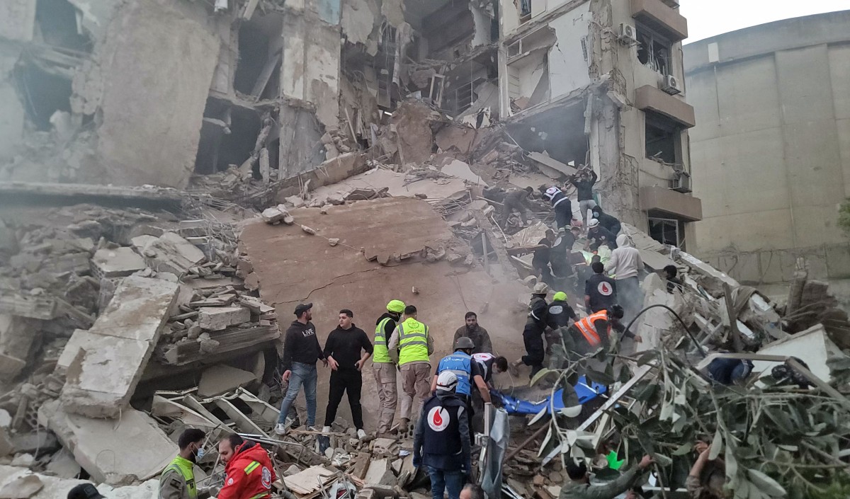 First responders and residents gather at the site of an Israeli airstrike in Beirut's Tallet al-Khayyat neighbourhood, on April 8, 2026. (AFP)