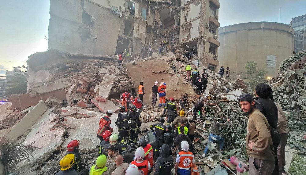 First responders and residents gather at the site of an Israeli airstrike in Beirut’s Tallet Al-Khayyat neighborhood, on April 8, 2026. (AFP)