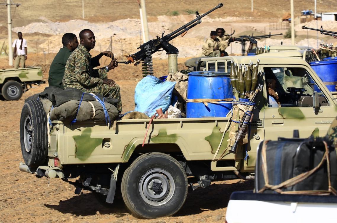 Members of the Sudanese paramilitary Rapid Support Forces (RSF) sit on an armed vehicle as they guard some 115 migrants from Somalia and Ethiopia in Omdourman, on the western outskirts of the capital Khartoum, after catching them travelling illegally on the Libyan-Sudan border on January 8, 2017. (FILE/AFP)