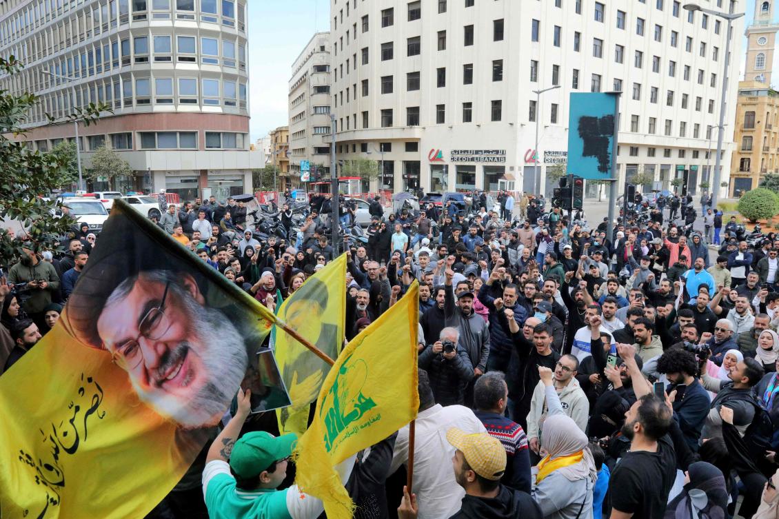 Hezbollah supporters wave a flag bearing a portrait of slain Hezbollah leader Hassan Nasrallah as they stage an anti-government protest outside the Lebanese governmental palace in Beirut on Apr. 9, 2026. (AFP)