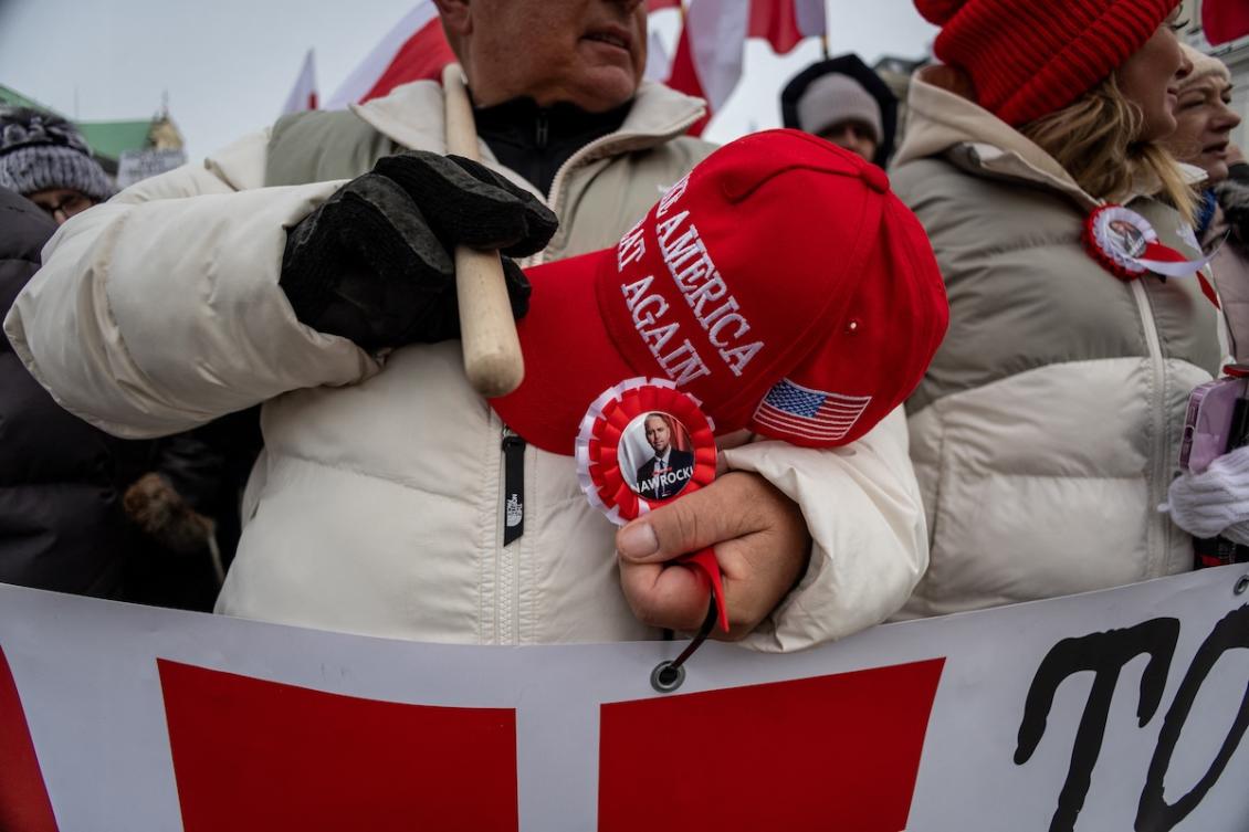 A man holds a MAGA (Make America Great Again) hat as he and other supporters of Poland's President Karol Nawrocki demonstrate in front of the presidential palace in Warsaw against the European Union's SAFE (Security Action for Europe) program on February 21, 2026. (FILE/AFP)