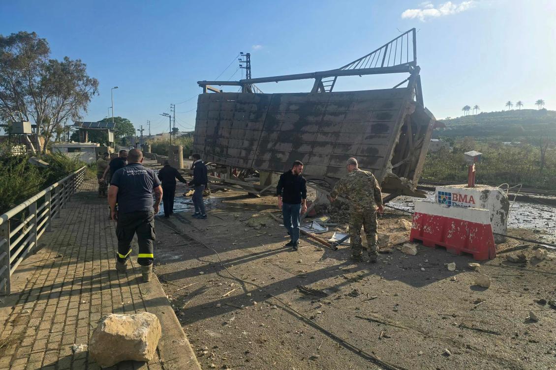 A picture taken on April 9, 2026 shows civil defense members inspecting the site of the previous day’s Israeli airstrike that targeted Qasmiyeh Bridge, located on a main highway linking villages in the Tyre district with others farther north. (AFP)
