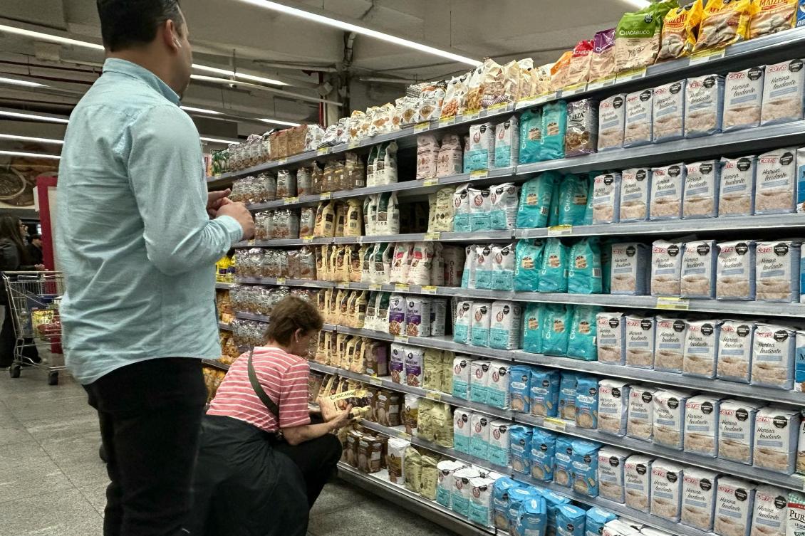 Above, people check the prices of flour at a supermarket in Buenos Aires on April 10, 2026. Inflation could increase by 200 to 300 basis points, with a much higher impact — of up to 0.9 percentage point — if the war continues, the World Bank said. (AFP)