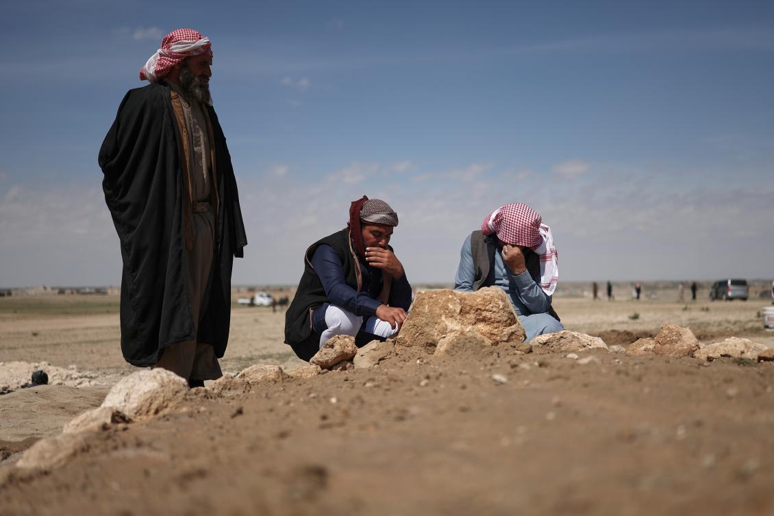 Mourners kneel by the graves of six people from the Al-Jalib family, who were killed Wednesday in Israeli strikes in Beirut, after their burial in the village of Al-Sour, Deir Al-Zour province, northeastern Syria, Apr. 11, 2026. (AP)