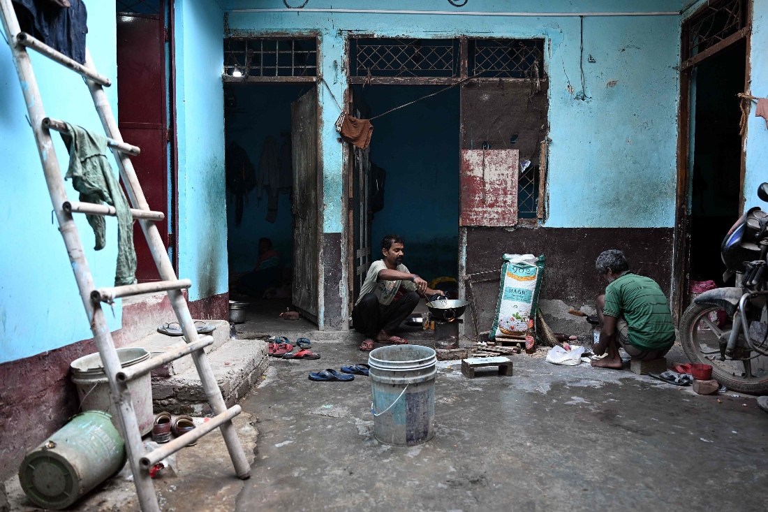 A migrant worker cooks food on a wood-fired stove outside his rented room in New Delhi, India. (AP)