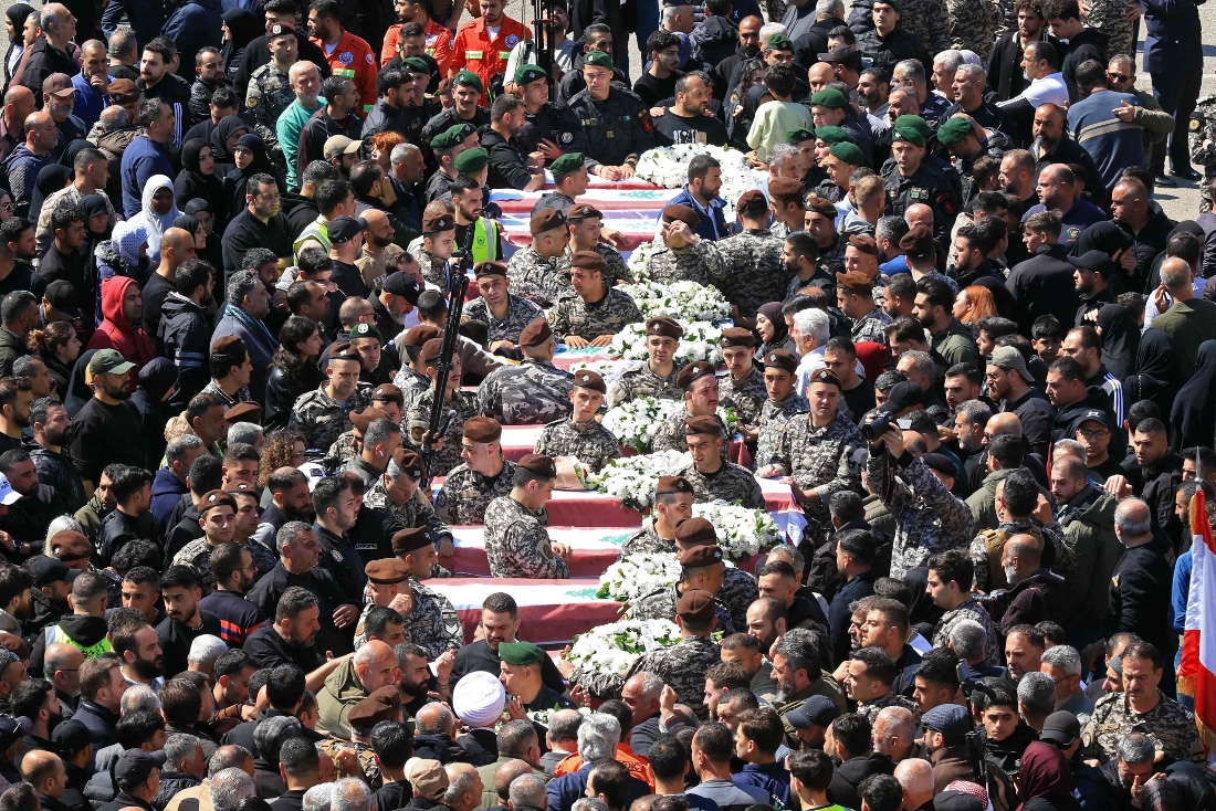 Mourners gather around the coffins of the members of Lebanon's State Security agency, who were killed by an Israeli strike, during their funeral in Sidon, Lebanon. (AFP)