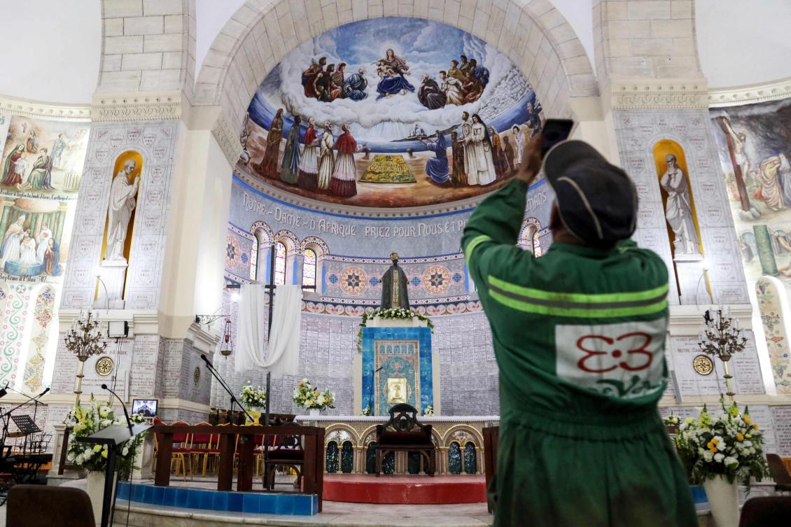 A worker takes a picture inside the Basilica of Our Lady of Africa in Algiers on April 12, 2026, as preparations are under way ahead of the pope's visit to Algeria. (AFP)