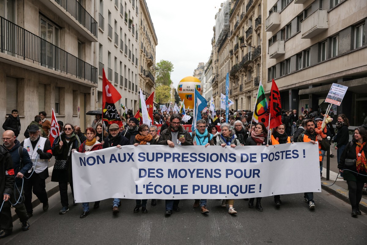 Protesters hold a banner reading "No to job cuts! Funding for public school!" during a teachers' demonstration in Paris, France. (AFP)