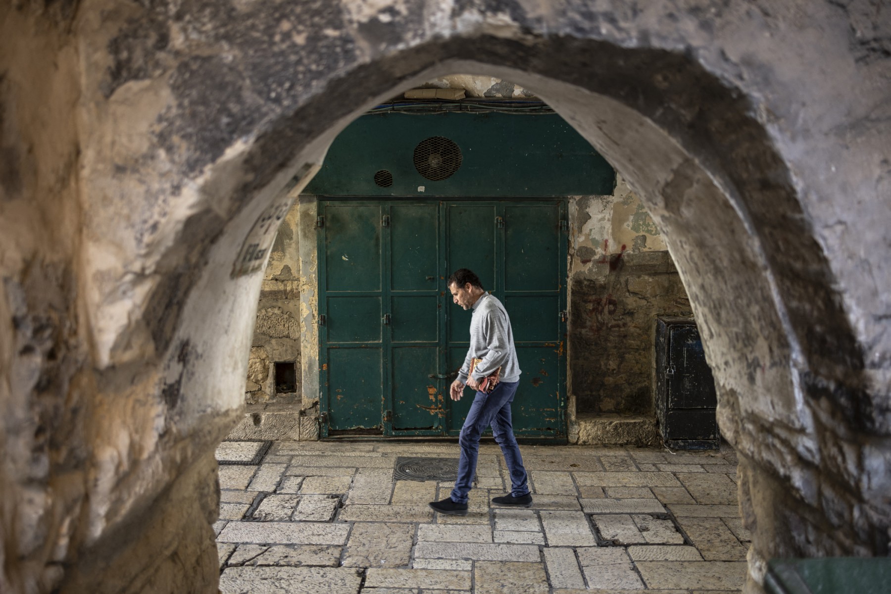 A man walks past a closed shop in the Old City of Jerusalem, March 13, 2026. (AFP)
