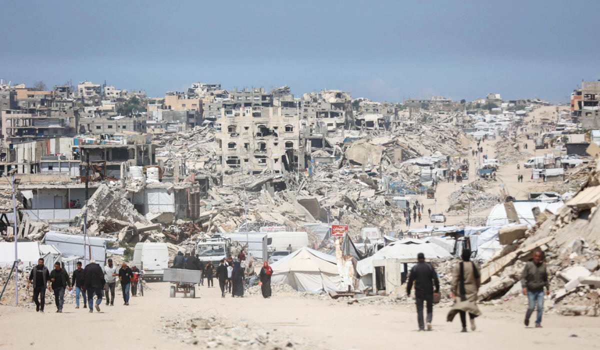 Palestinians walk amid the rubble of destroyed buildings in the Jabalia refugee camp in the northern Gaza Strip on April 13, 2026. (AFP)