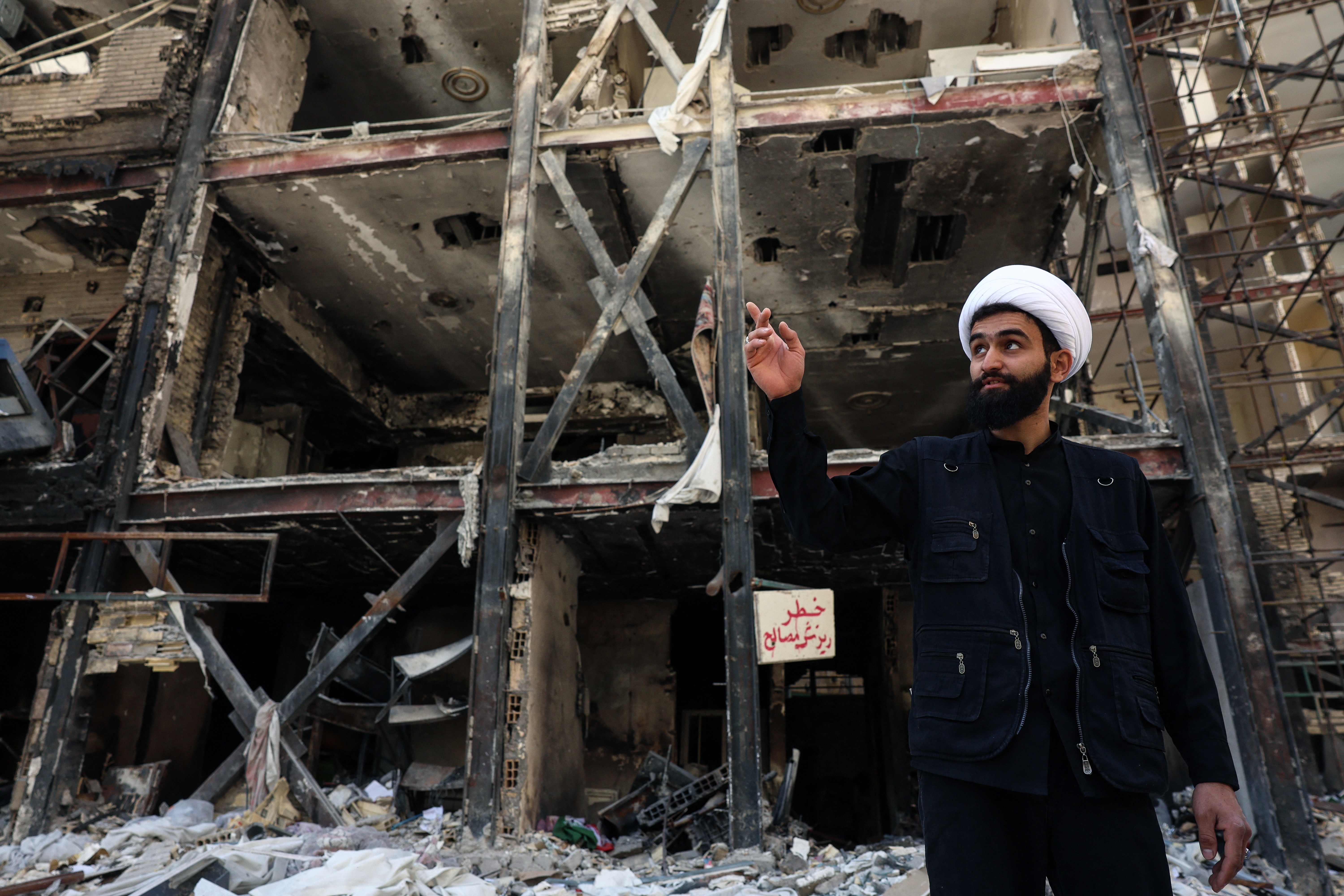 An Iranian cleric speaks to the media in front of a residential building in southern Tehran that was hit by US-Israel airstrikes days before a two-week ceasefire took effect. (AFP)