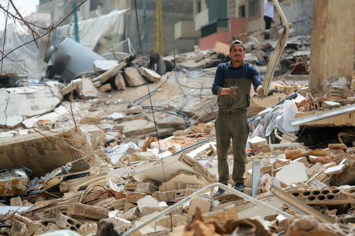 A displaced clears the rubble of damaged buildings as residents return to their homes in Beirut’s southern suburbs on Apr. 18, 2026. (AFP)