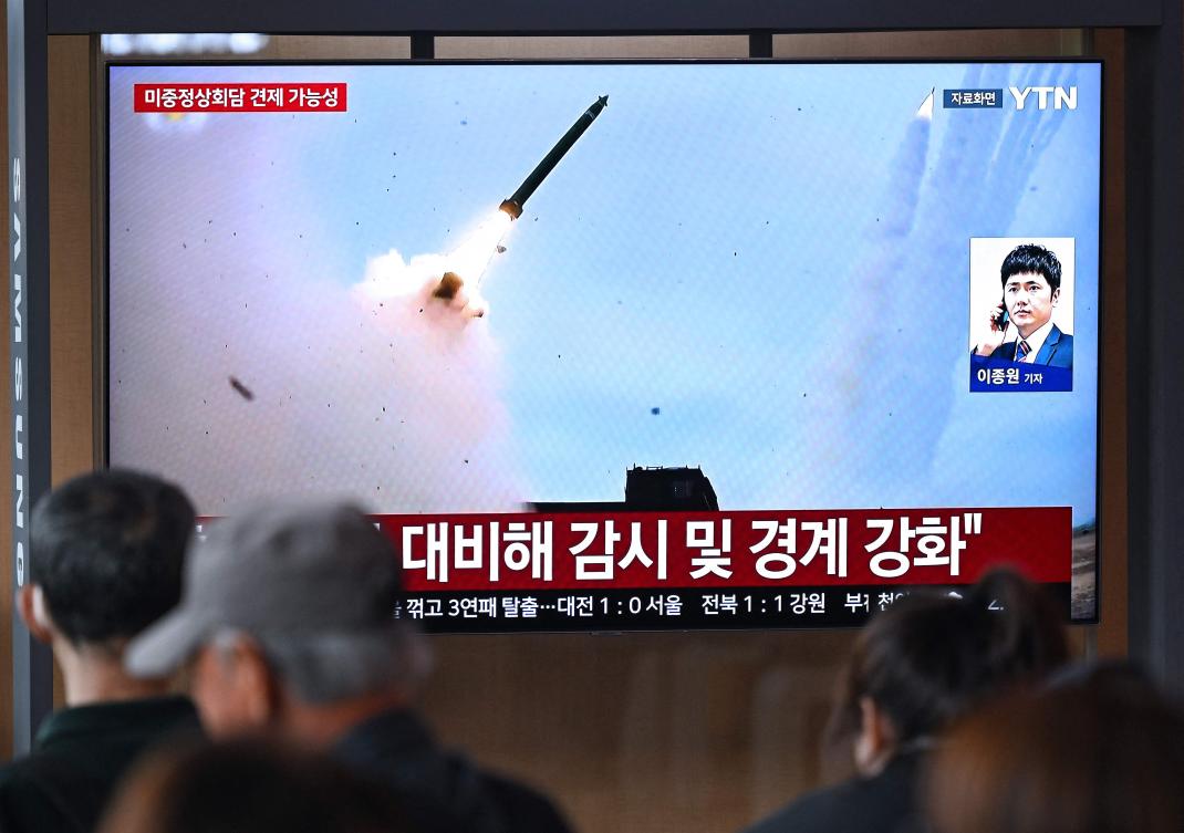 People watch a television screen showing a news broadcast with file footage of a North Korean missile test at a train station in Seoul on April 19, 2026. (AFP)
